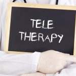 A Therapist Holding a Board With Teletherapy Word Promoting Teletherapy and Telehealth SEO