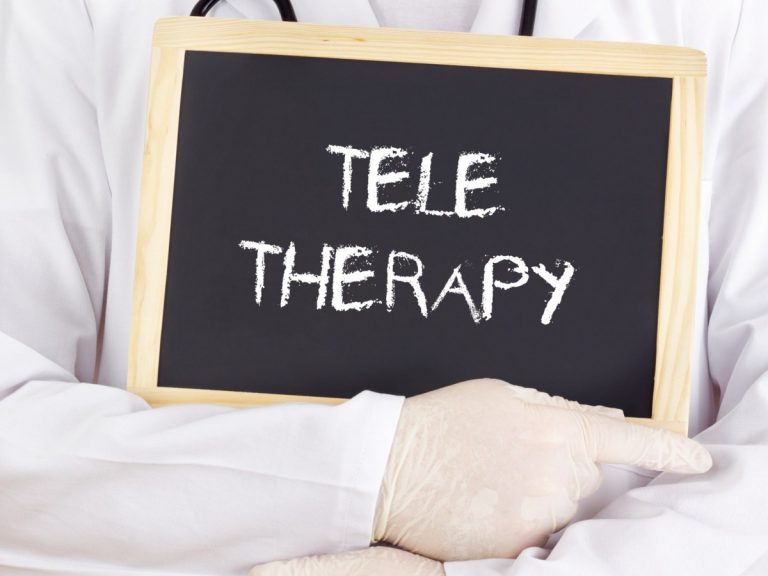 A Therapist Holding a Board With Teletherapy Word Promoting Teletherapy and Telehealth SEO