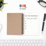 New Year Resolutions Concept On White Desk With Glass, Pen, Cellphone., Tablet, Keyboard and A Mouse Promoting New Year Resolution – Overcome Your Fear of SEO