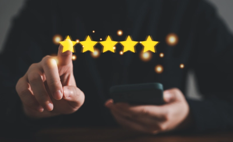 a person holding a phone and pointing at a five star rating