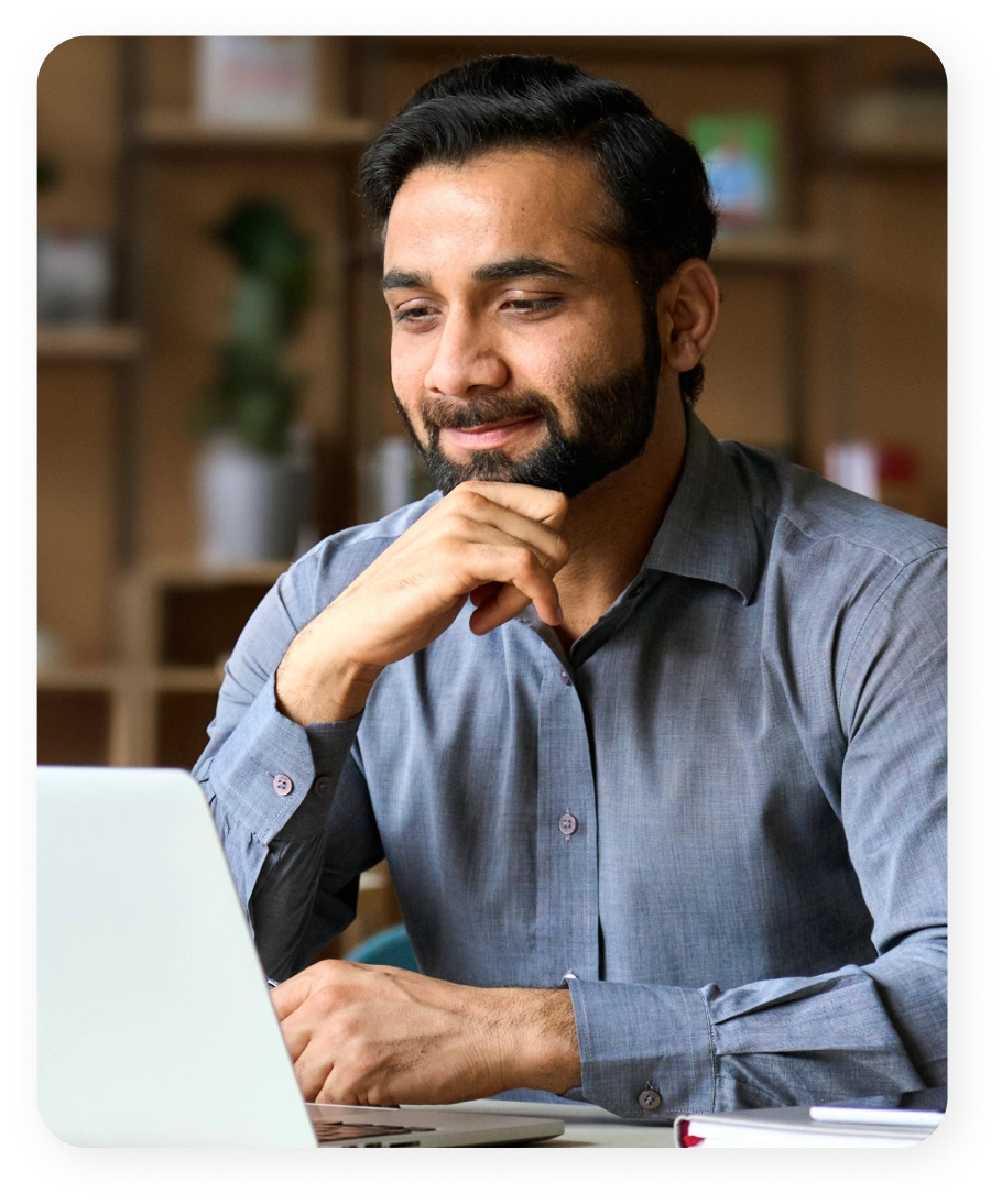 Man seated at a desk looking at a laptop screen for SEMrush Affiliate Program