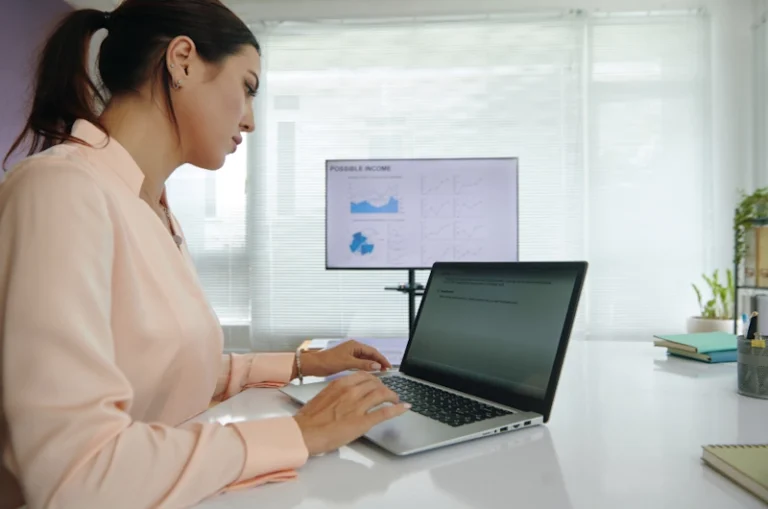 A professional working on a laptop at a desk, illustrating a step in how to become an SEO specialist.