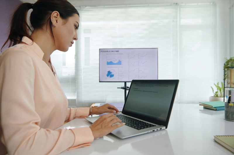 A professional working on a laptop at a desk, illustrating a step in how to become an SEO specialist.